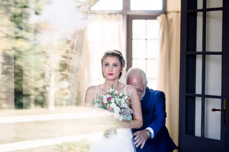 The bride, moved, on her father's arm before the ceremony