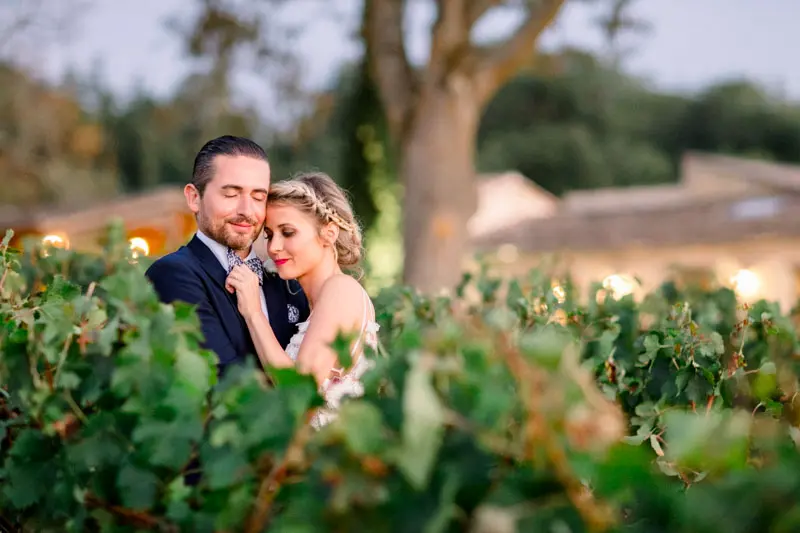 The couple embracing in the vines at dusk at Château de Garde