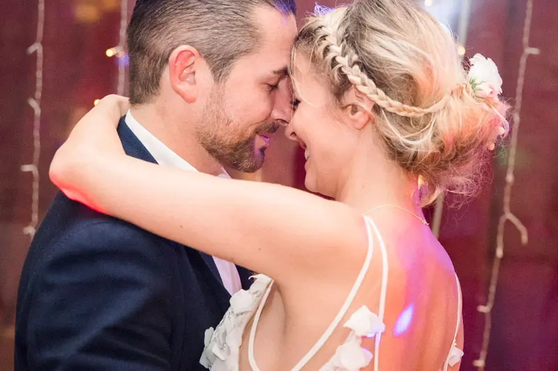 The bride and groom forehead to forehead during their first dance