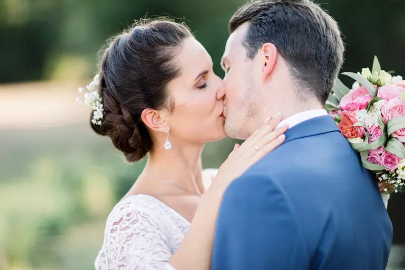 Bride and groom kissing in the golden light of the Château Giscours park