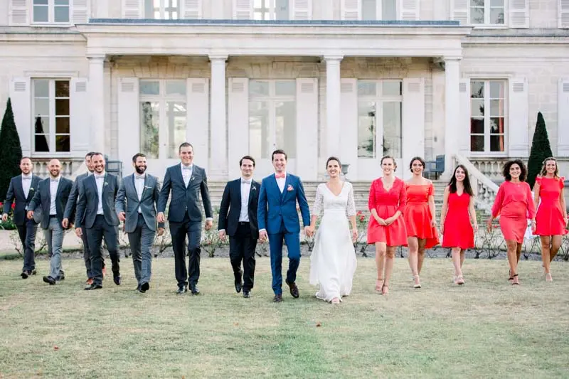 Bride, groom and wedding party walking before the Château Giscours façade