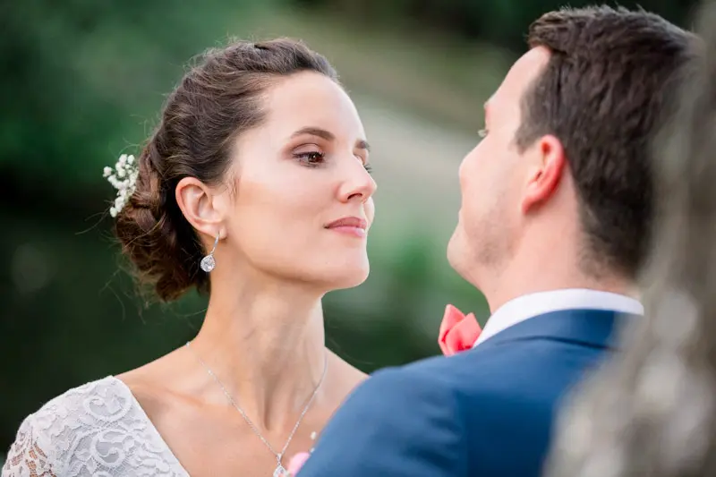 Bride gazing softly at the groom, flowers tucked in her chignon