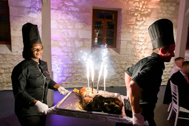 Chefs in toques bringing in a dish topped with sparklers