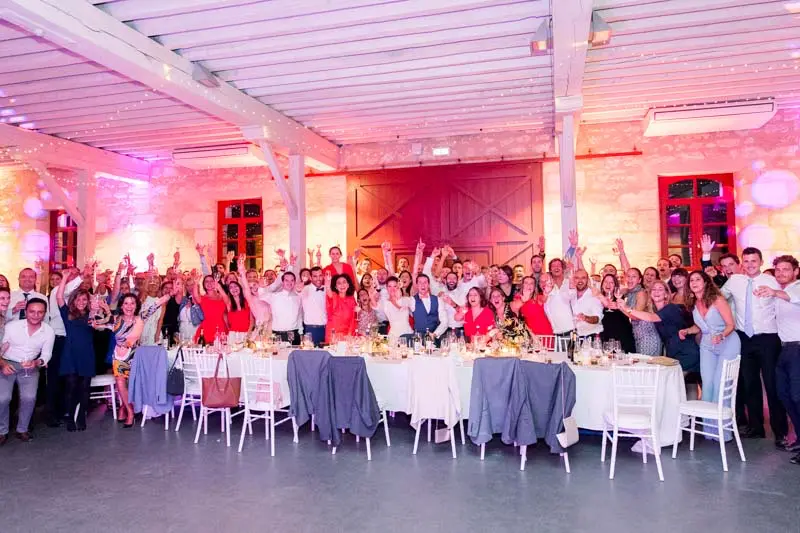 All the guests gathered with raised arms in the pink-lit hall