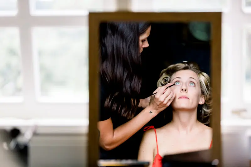 Bride's reflection in a mirror as her make-up is applied
