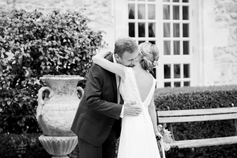 The bride's father seeing her in her dress and hugging her, black and white