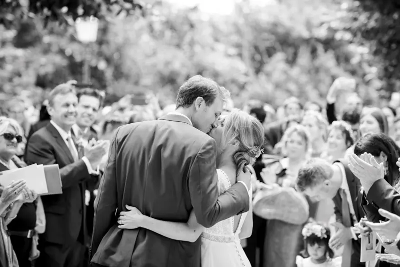 Bride and groom congratulated by guests after the ceremony, black and white