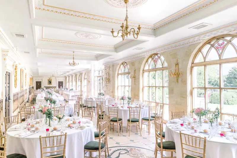 Arched reception hall with gilded chandeliers at Château de la Ligne