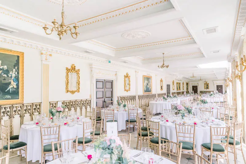 Round tables set beneath the ornate mouldings of the reception hall