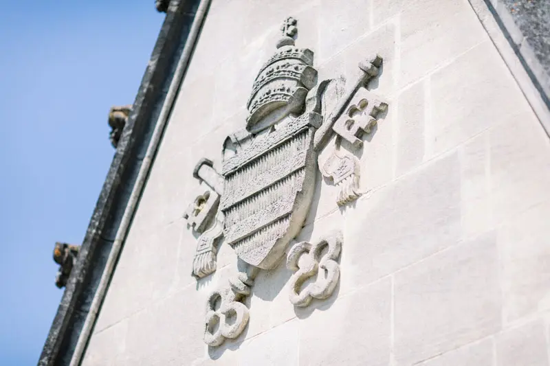 Papal coat of arms carved into the stone gable of Château Pape Clément