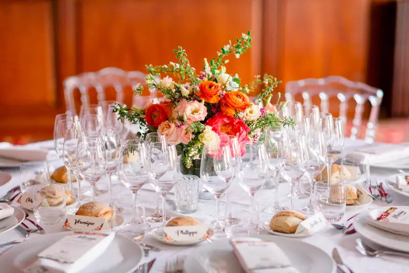 Wedding table detail with crystal glasses and coral flowers