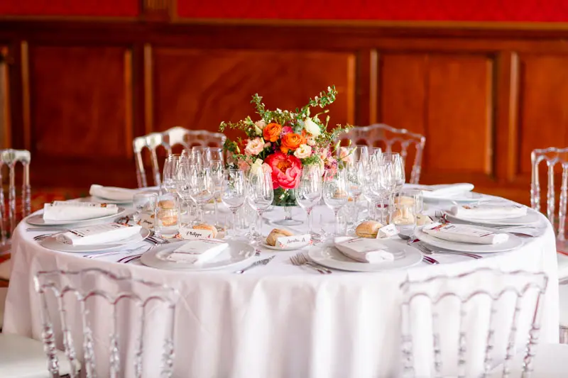 Round table set with an orange flower centrepiece