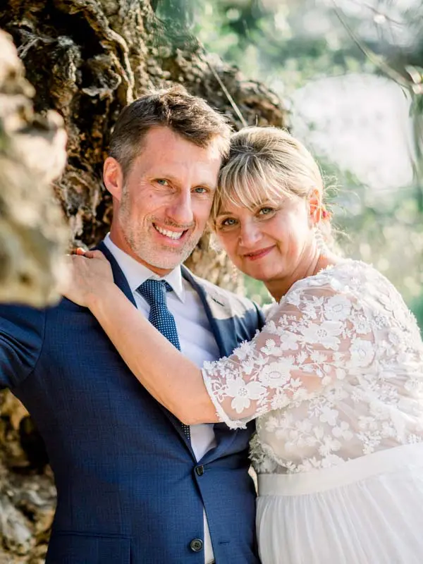 Close portrait of the smiling bride and groom before an old tree