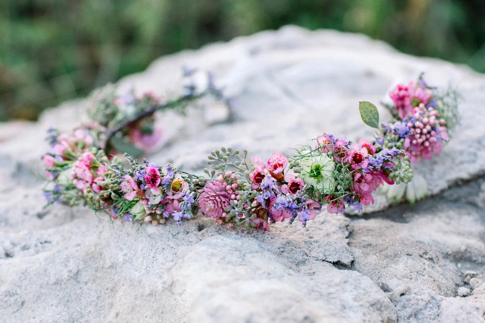 Pink and purple flower crown resting on a rock