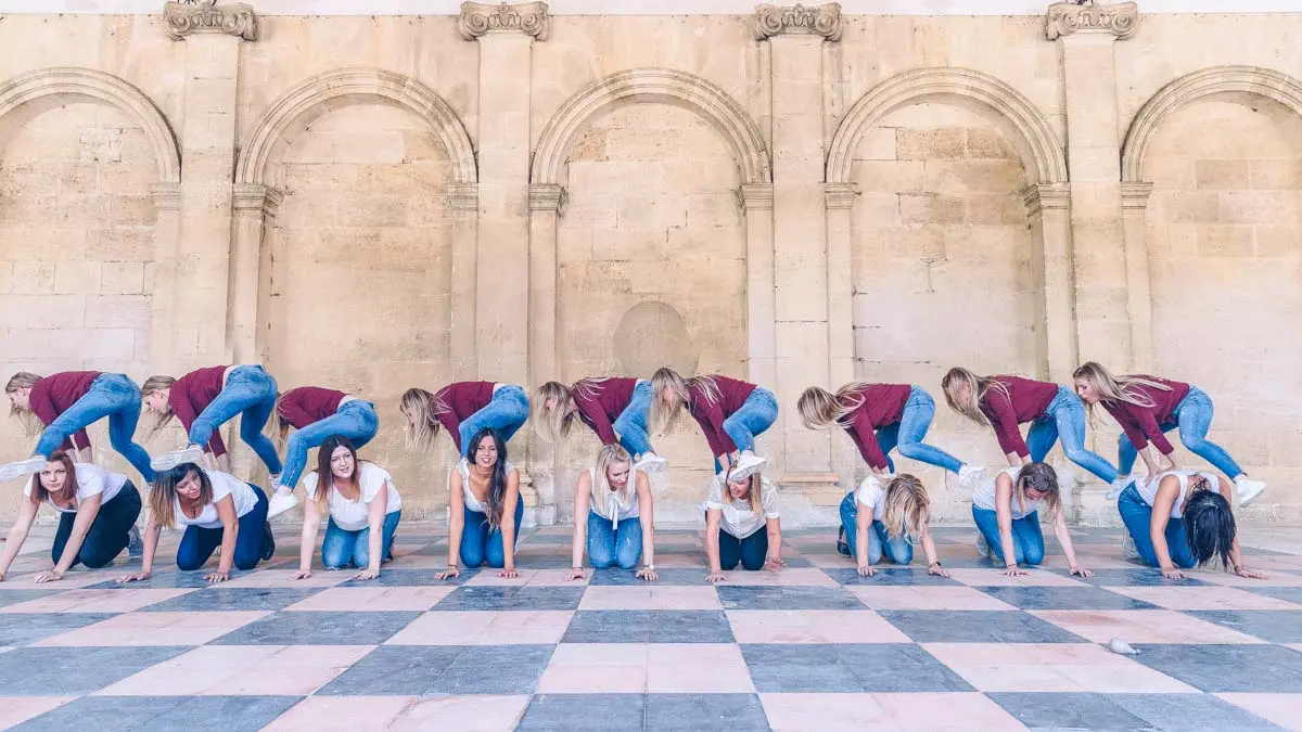 Hen party friends posing in a line before stone arcades in Bordeaux