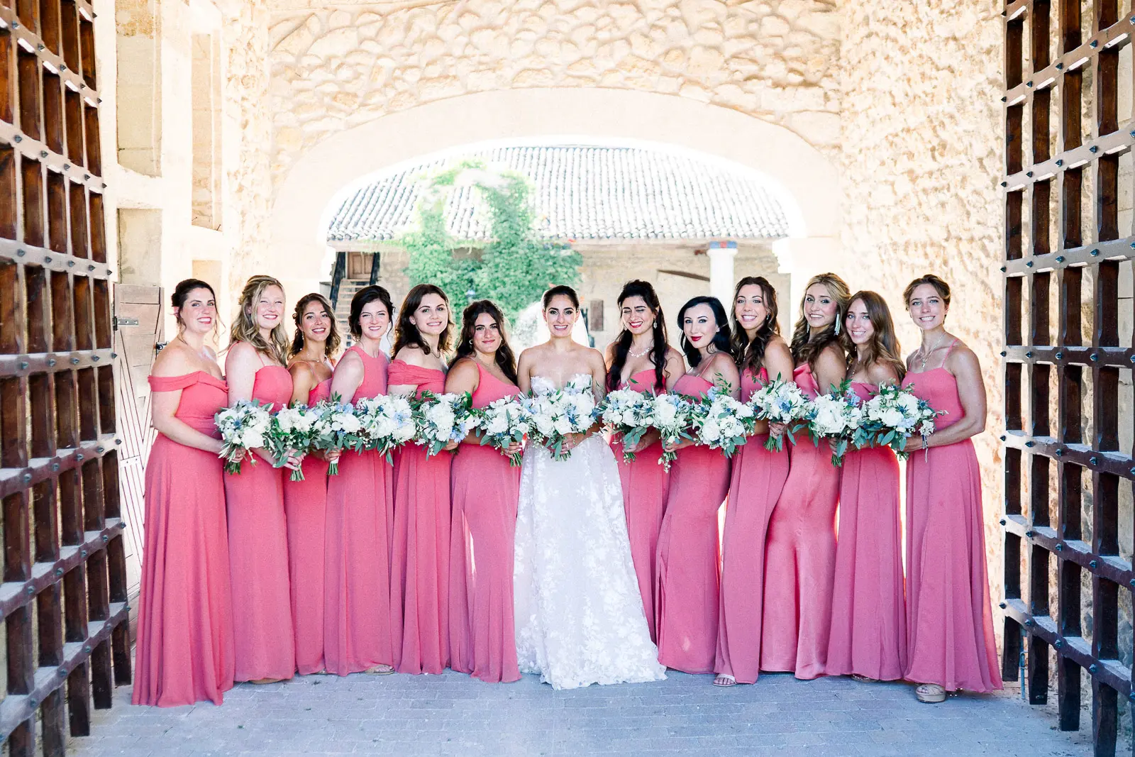 Bride surrounded by her bridesmaids in pink gowns at Château de la Ligne