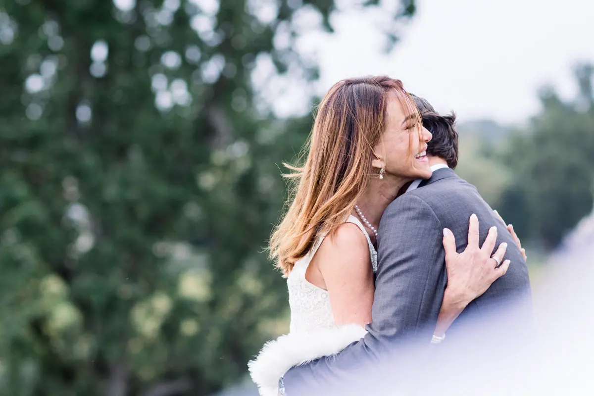 A couple in a tender embrace outdoors, the woman in a white dress