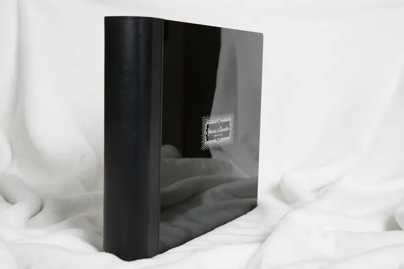 Livre photo de mariage noir debout, couverture laquée reflétant la lumière