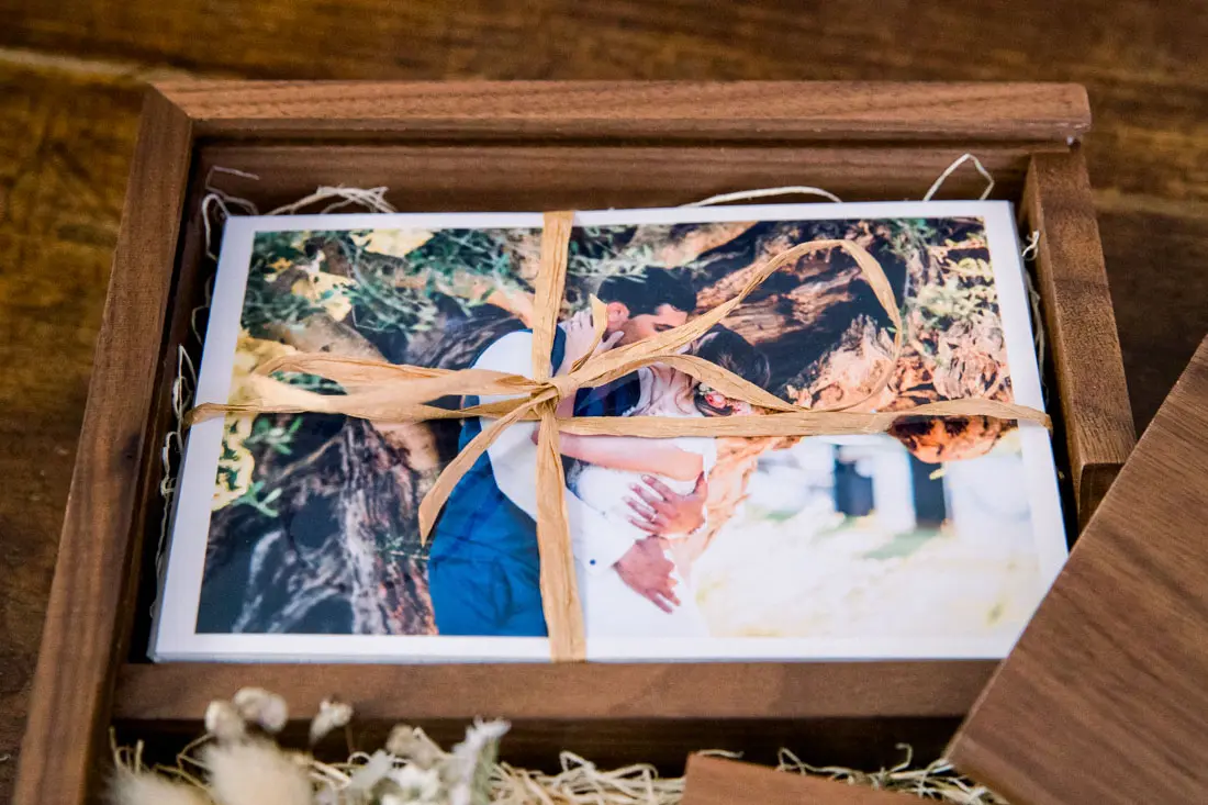 Photo prints tied with ribbon in the walnut wooden box
