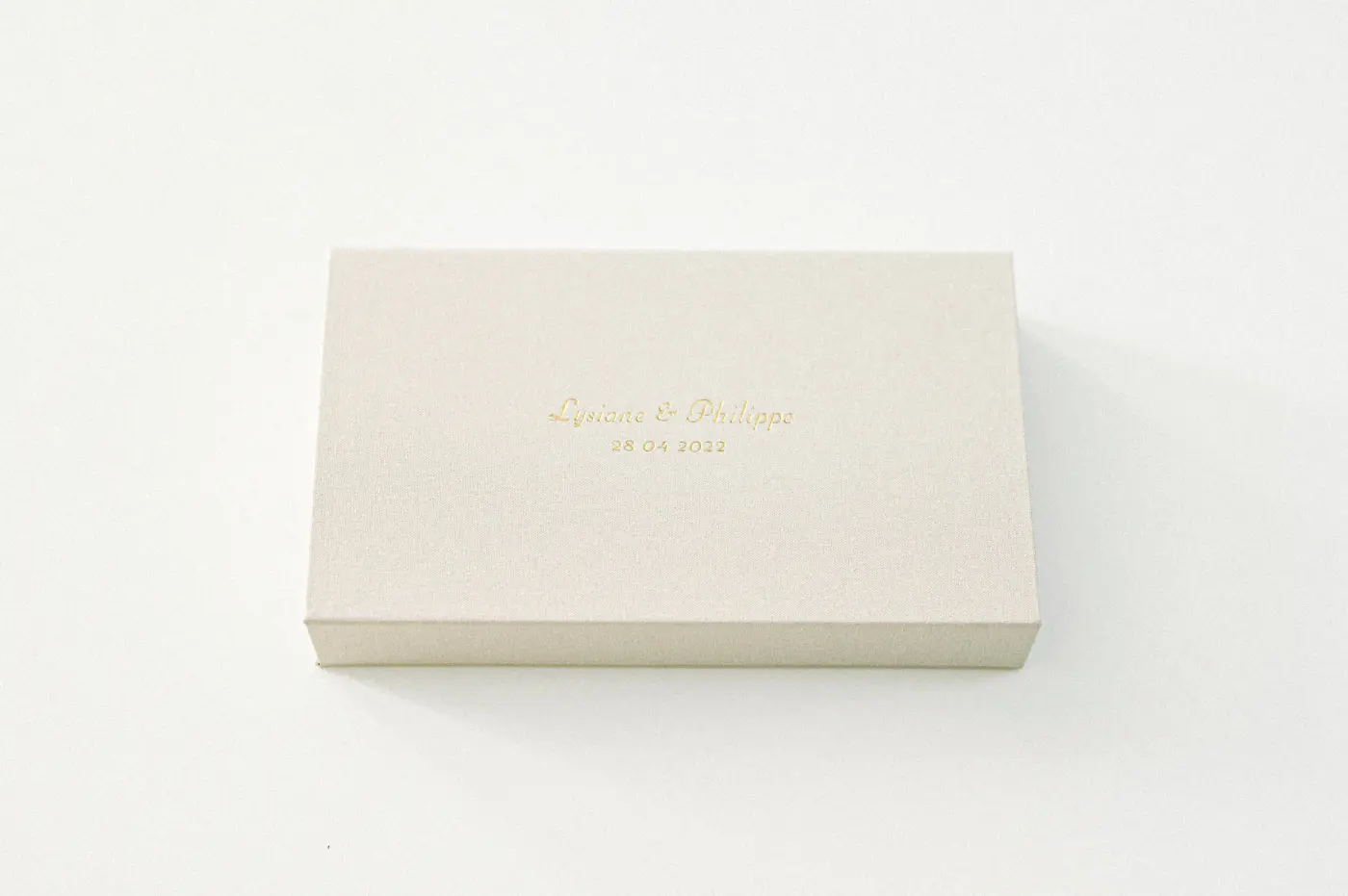 Closed linen wedding photo box on a white background