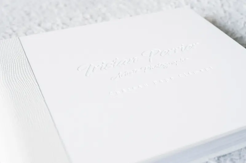 Gravure ton sur ton sur la couverture blanche d'un livre photo de mariage