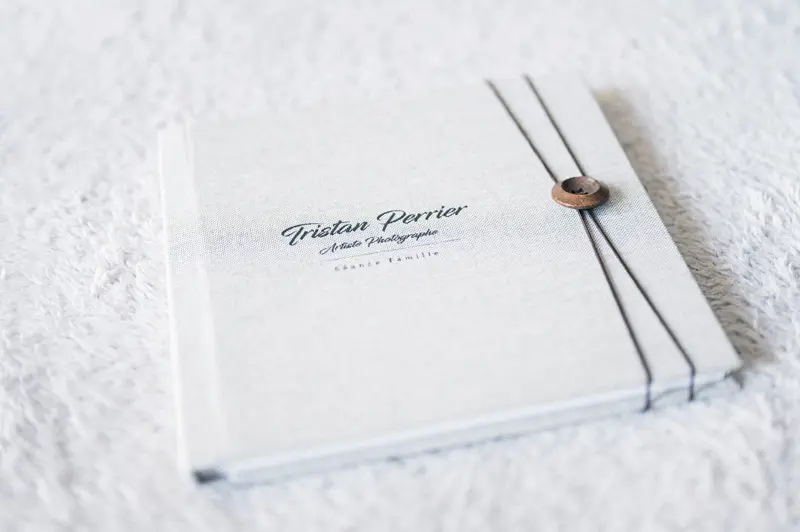 Family photo book on a white fur rug, title on the cover