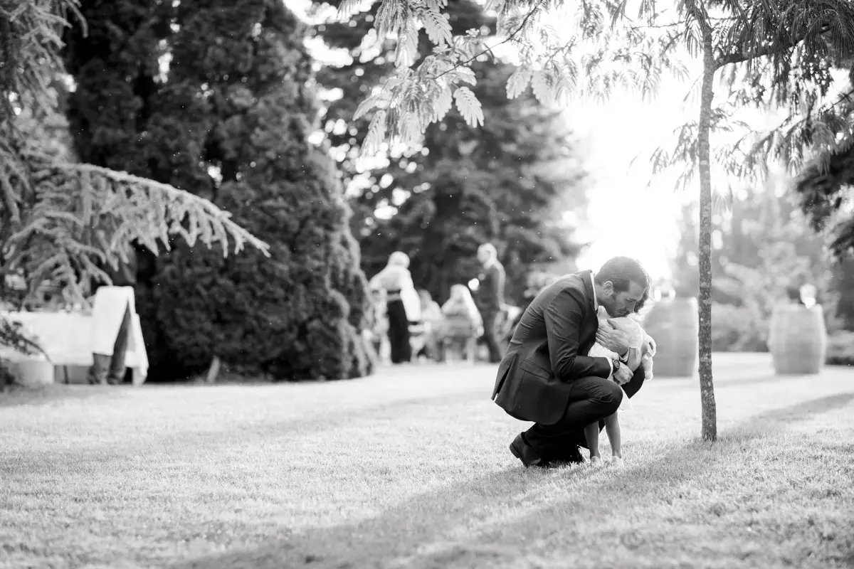 Dad crouching with his child in a garden, black and white