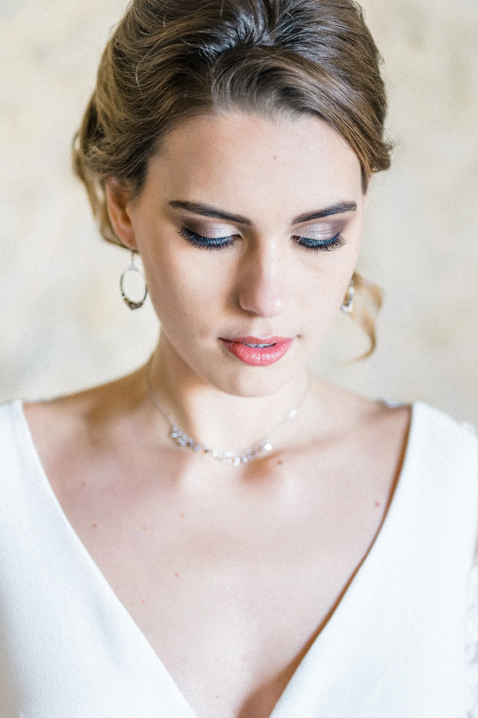 Gros plan sur le maquillage de la mariée aux yeux baissés