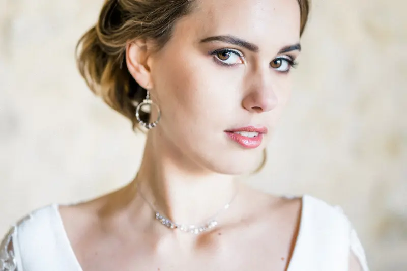 Three-quarter portrait of the bride with a fine necklace and low bun