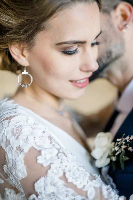 Close-up of the smiling bride against the groom, lace sleeves