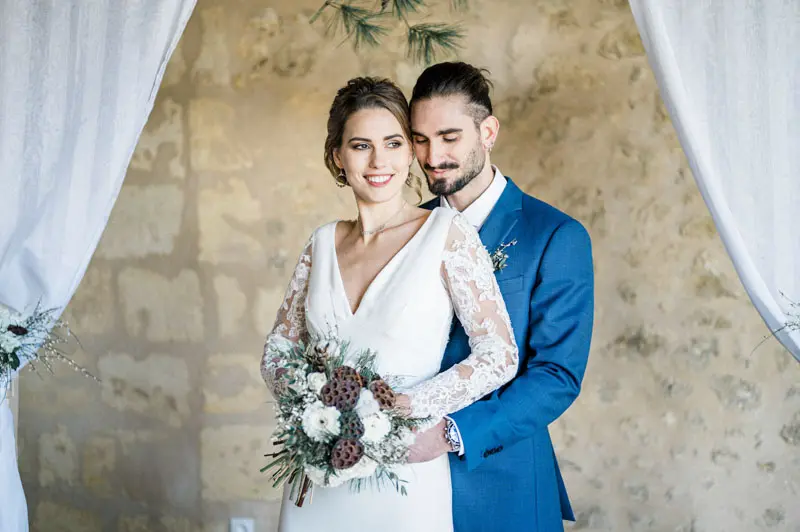 The couple beneath white drapes, the groom resting eyes closed against the bride