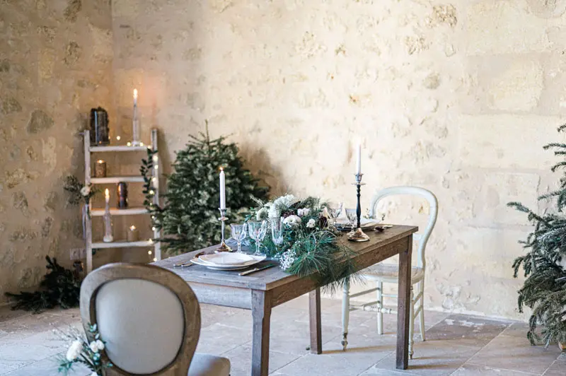 Wedding table set for two with fir and candle decor in the barn