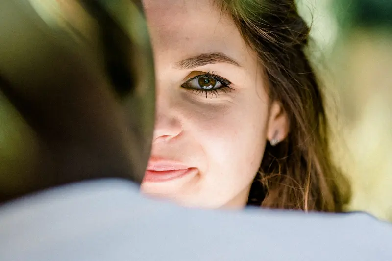 The bride-to-be gazing over her partner's shoulder