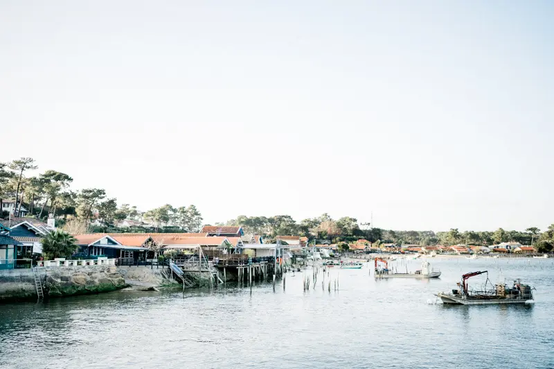 Oyster huts and boats on the shore of Arcachon Bay