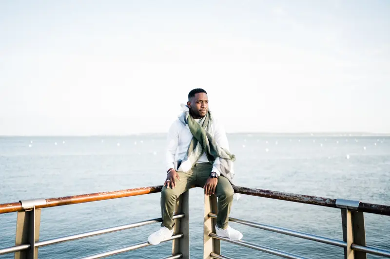 The groom-to-be sitting on the jetty railing overlooking Arcachon Bay