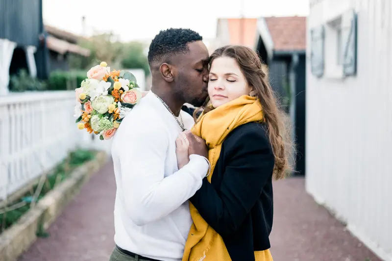 He kisses her between the wooden oyster huts