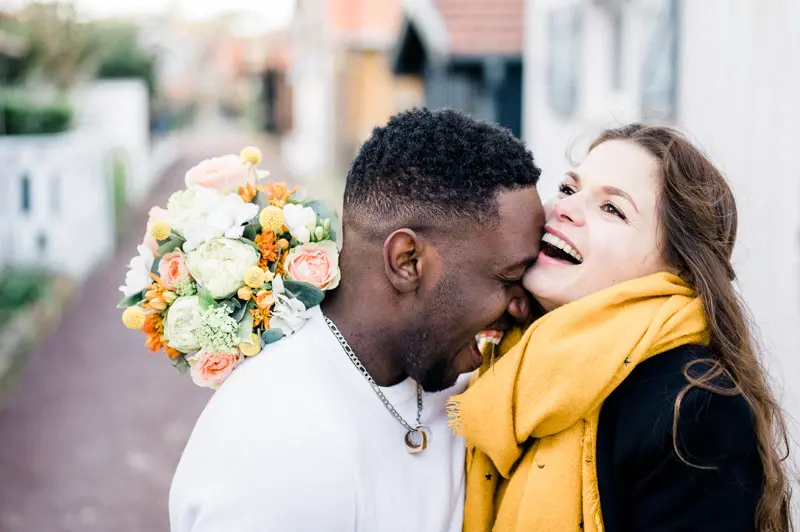The couple cheek to cheek, laughing in the oyster village
