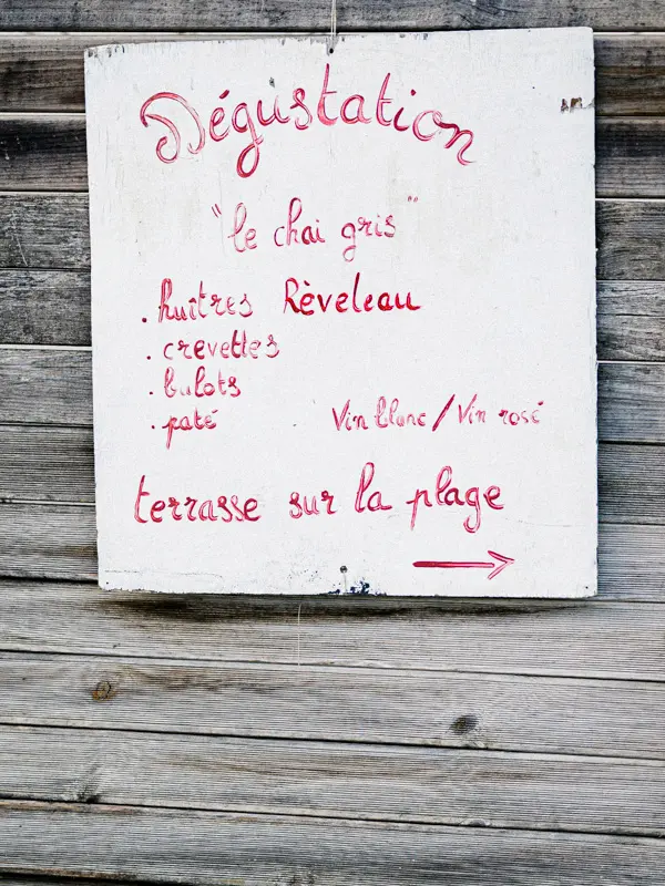 Handwritten oyster tasting sign on a wooden hut