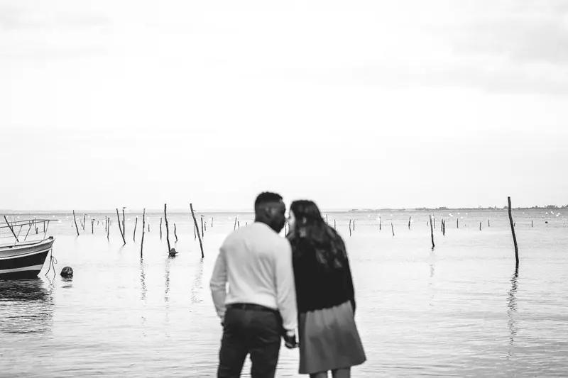 The couple facing the bay among oyster stakes, in black and white