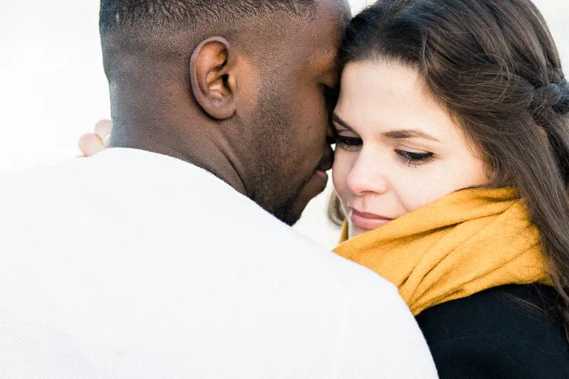 The bride-to-be nestled against her partner, wearing a yellow scarf