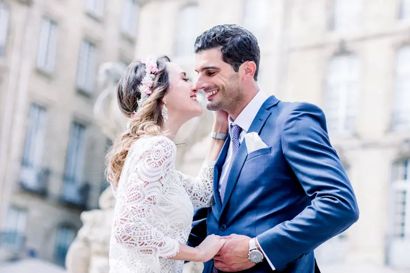 The bride and groom laughing in an embrace on a Bordeaux street