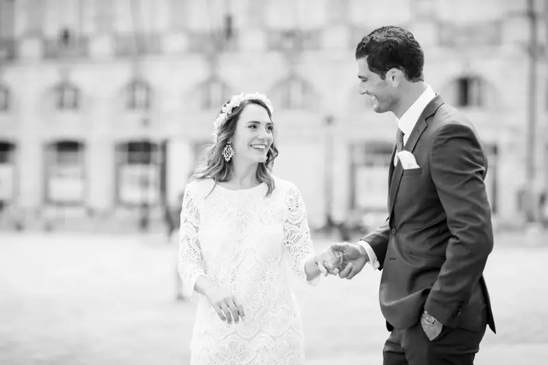 The bride and groom hand in hand at the water mirror, in black and white