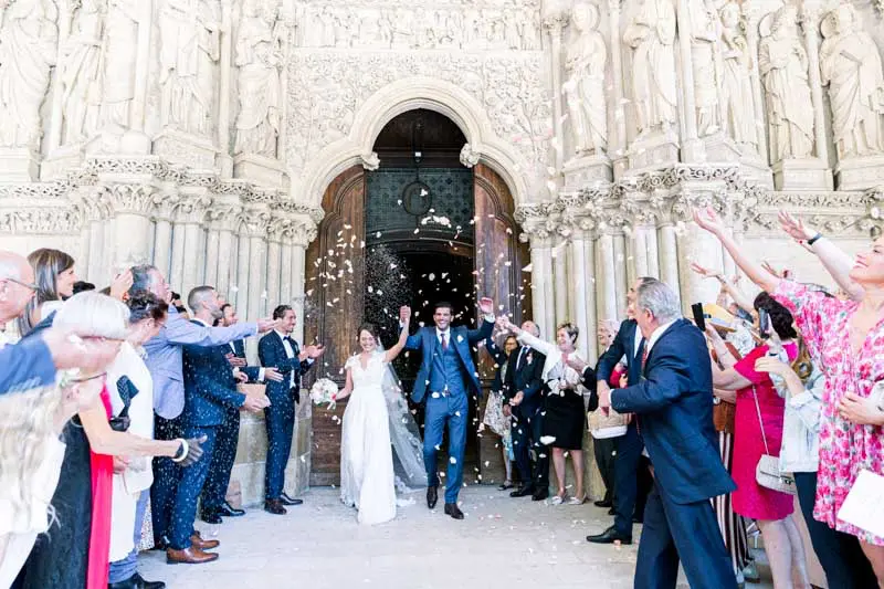 The couple leaving the basilica under petals thrown by guests