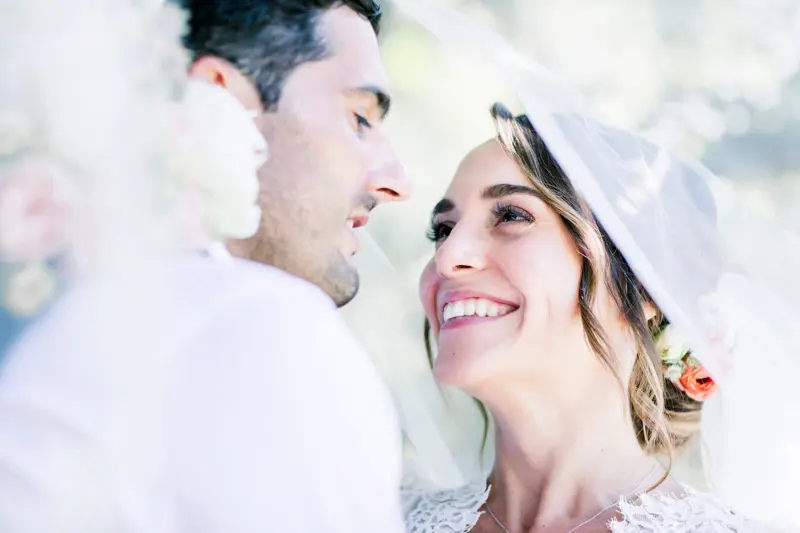 The bride and groom smiling forehead to forehead in soft light