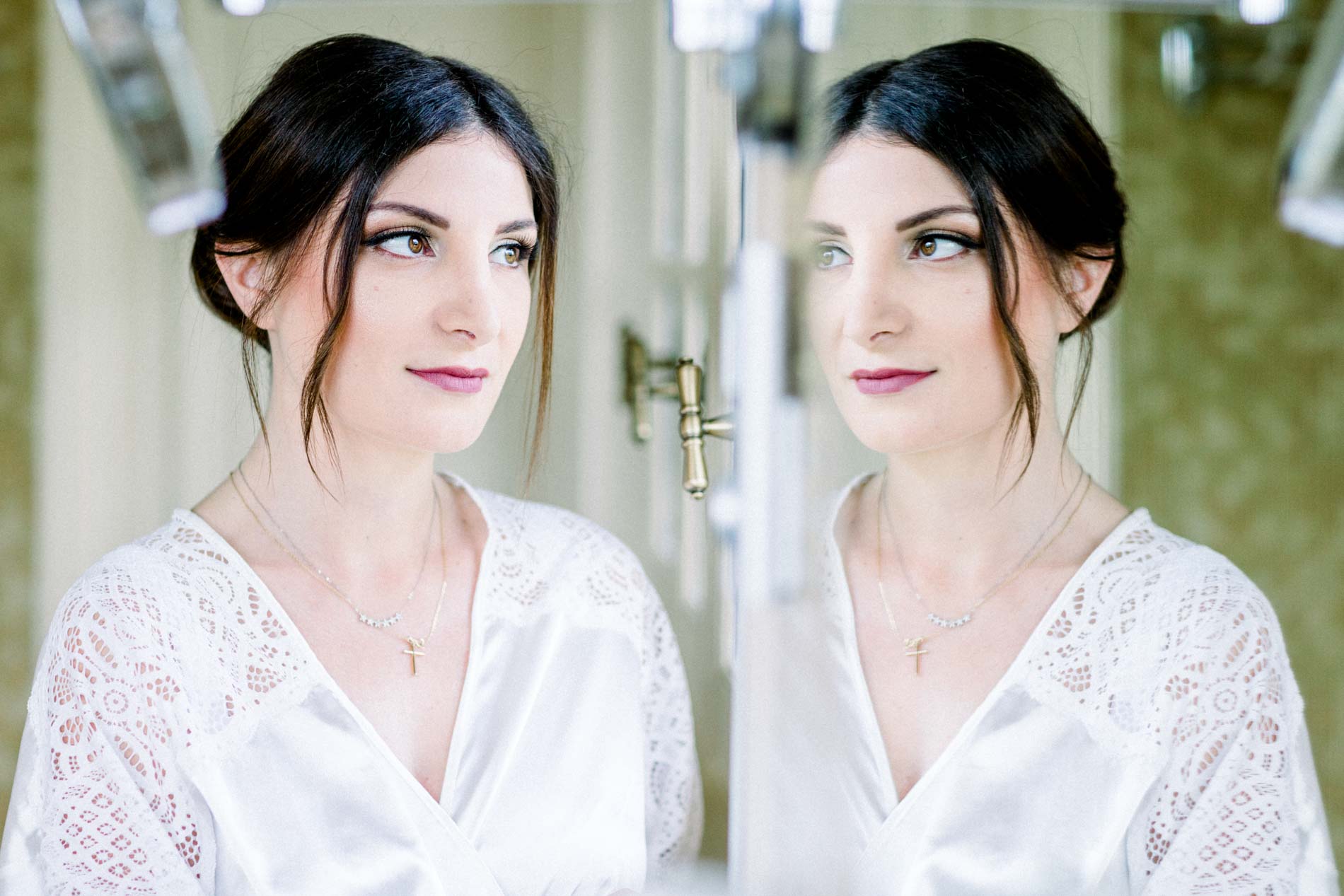 The bride looking at her reflection in a mirror while getting ready
