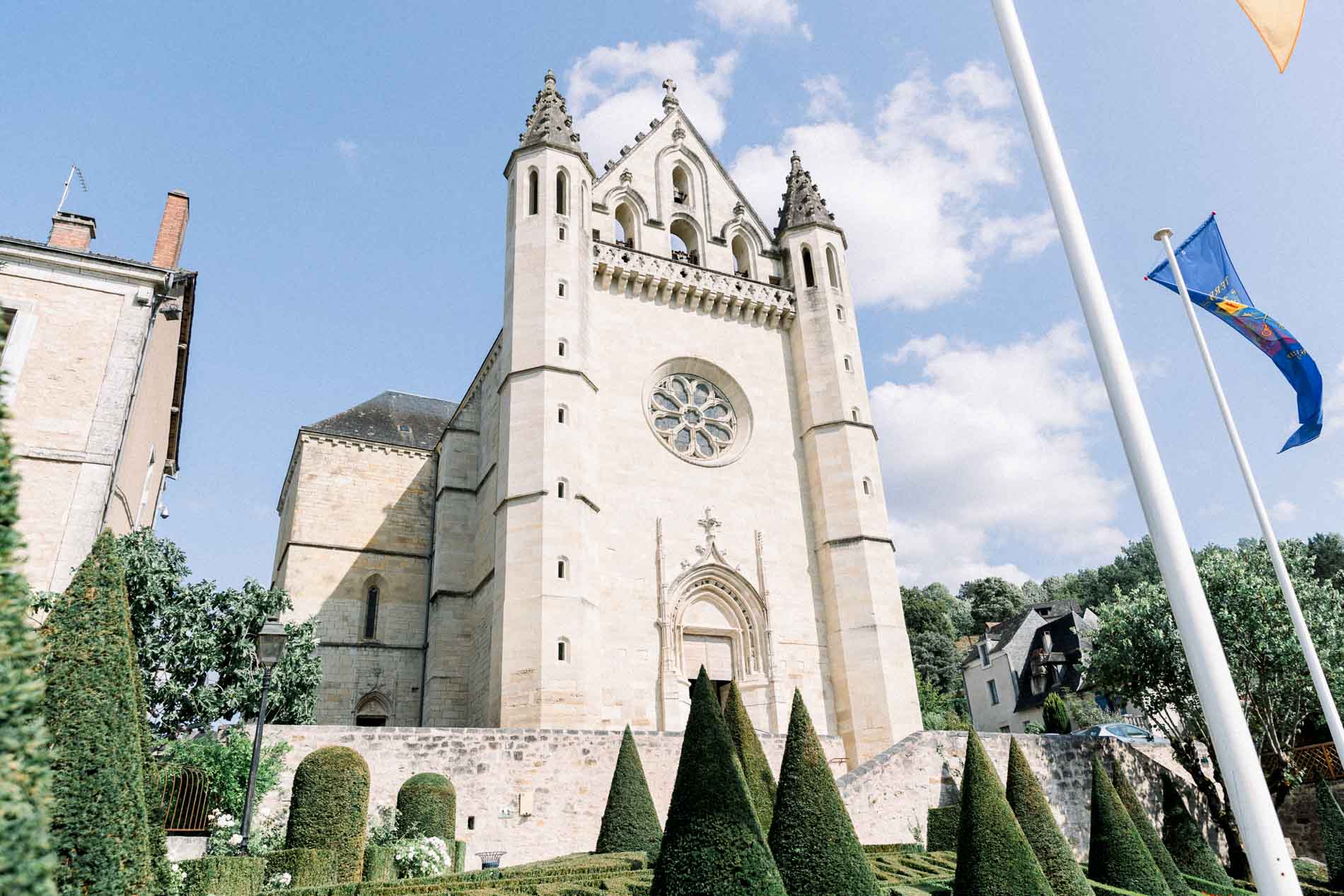 Terrasson church and its bell tower under a blue sky before the ceremony