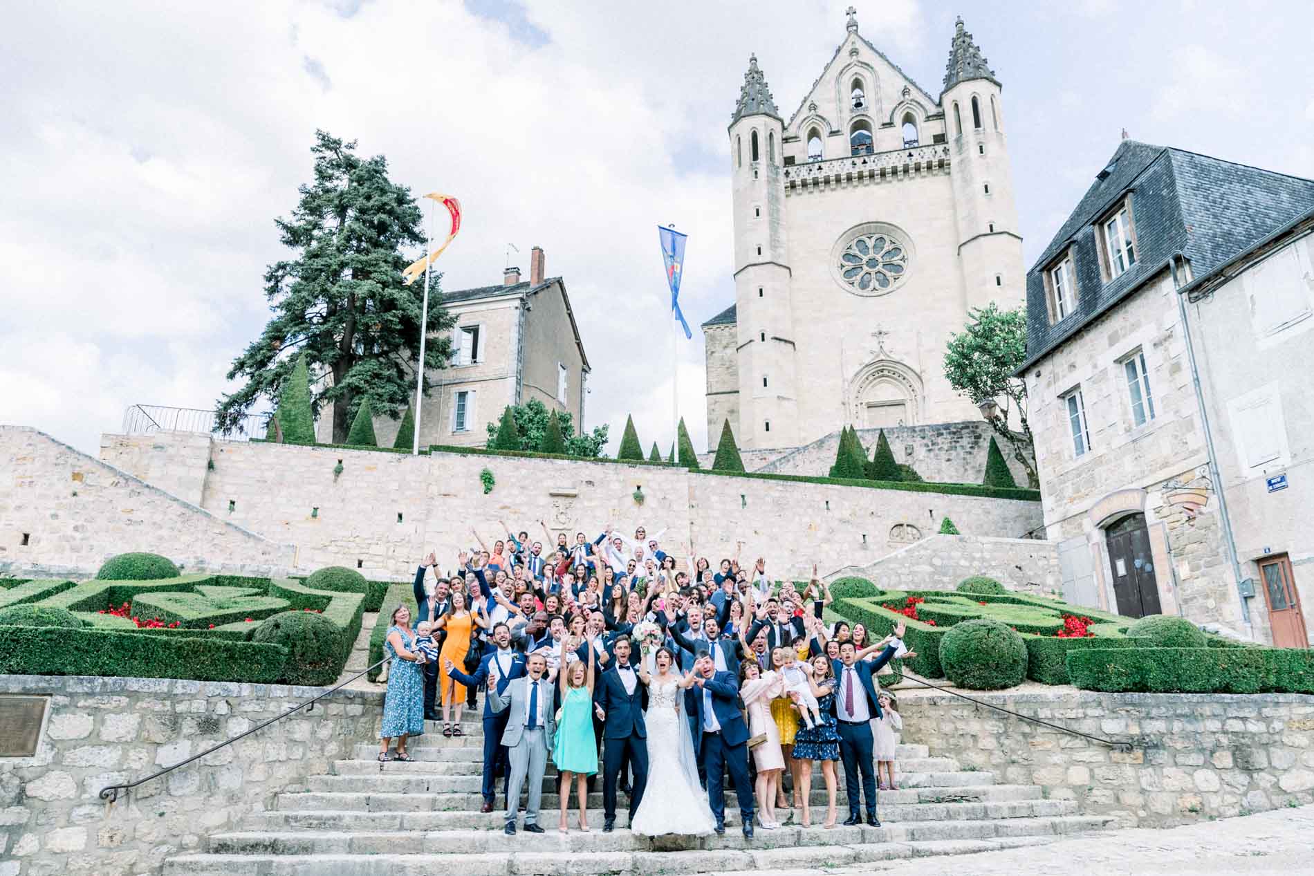 Group photo of the guests on the steps in front of Terrasson church