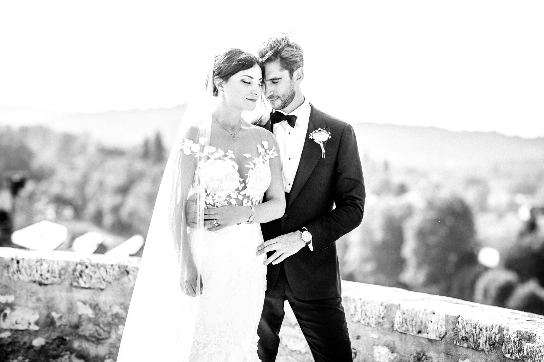 The bride and groom embracing above the valley, in black and white