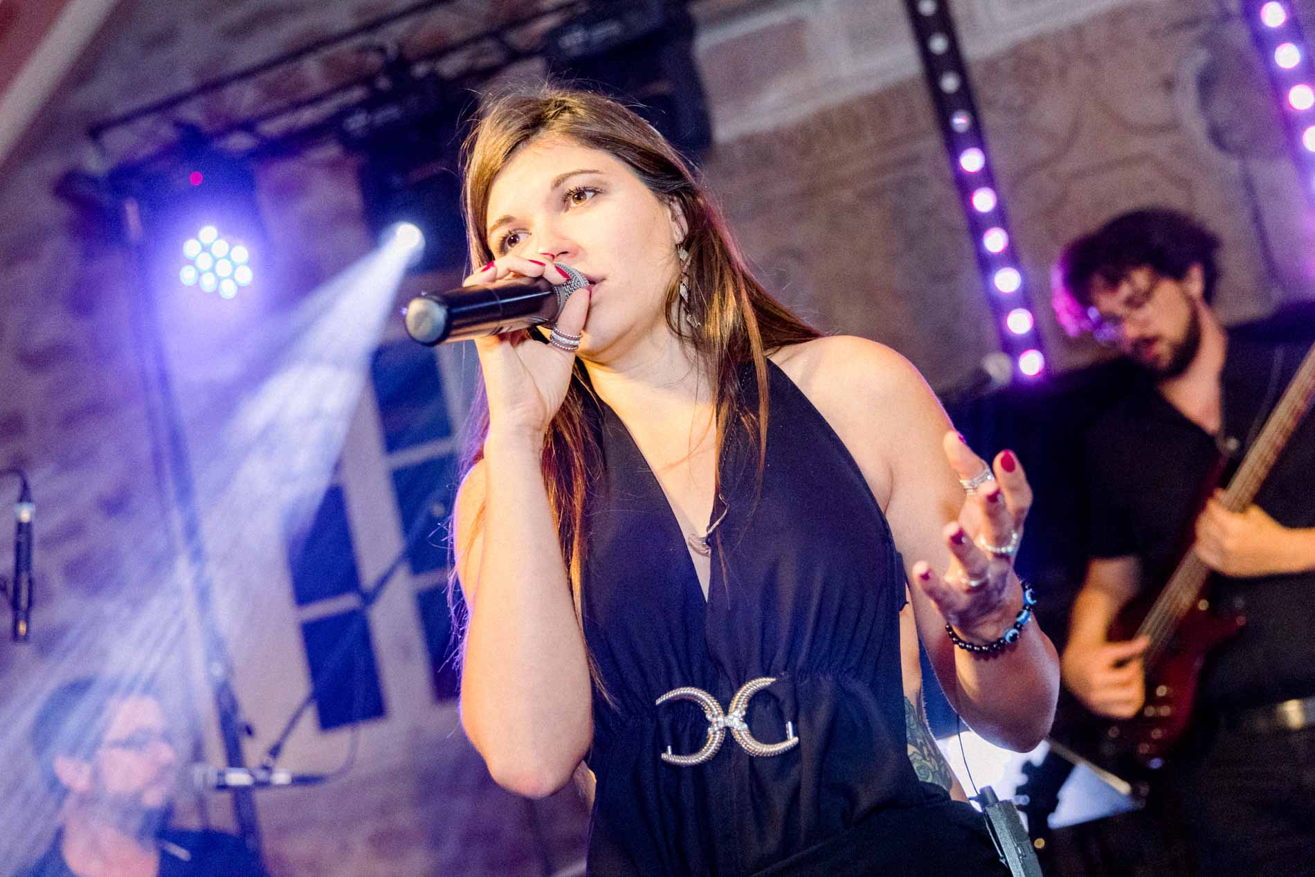 The Smart Music band's singer at the microphone under stage lights