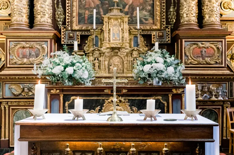 Autel et retable baroque doré décorés de fleurs blanches pour le mariage